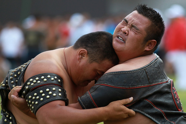 Wrestlers compete during the opening day of the year's Naadam Festival in Xinlin Gol, situated on the grasslands of the Inner Mongolia autonomous region, Aug 8, 2013. 