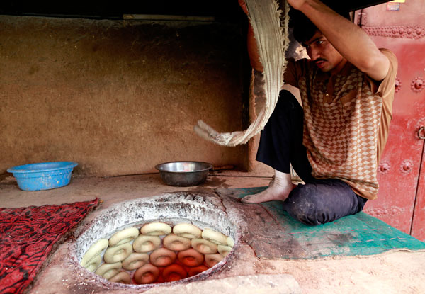 A man makes naan bread. Chen Tao