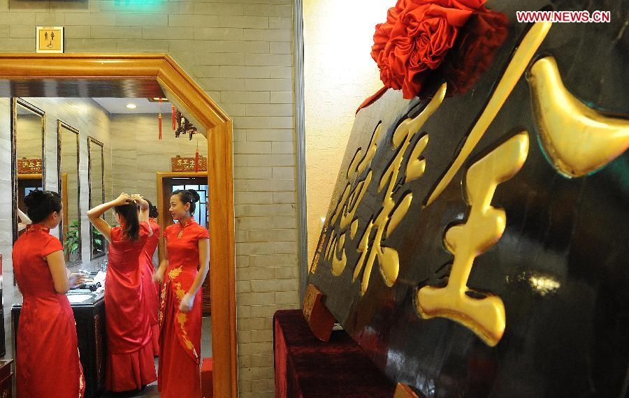 Waitresses prepare for a ceremony for the 150th anniversary of Quanjude Beijing Roast Duck Restaurant at its Qianmen Branch in Beijing, capital of China, July 2, 2014. [Photo/Xinhua]