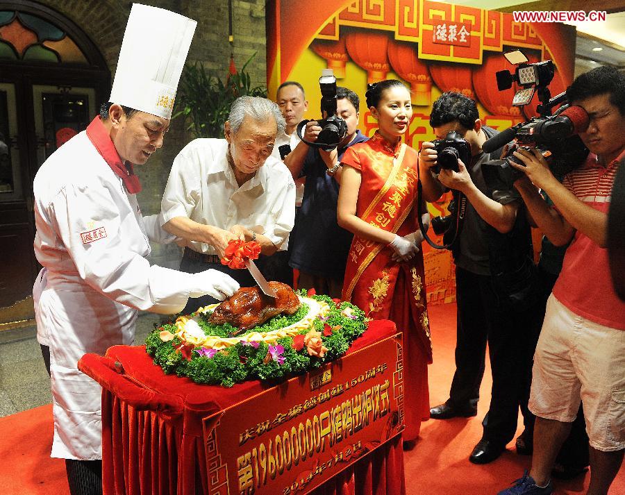 Yang Dengyan (2nd L), the first president of Quanjude Group, slices Quanjude's 196 millionth roast duck during a ceremony to celebrate the 150th anniversary of Quanjude Beijing Roast Duck Restaurant at its Qianmen Branch in Beijing, capital of China, July 2, 2014. [Photo/Xinhua]
