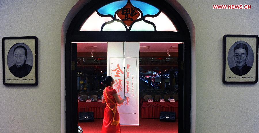 A waitress prepares for a ceremony for the 150th anniversary of Quanjude Beijing Roast Duck Restaurant at its Qianmen Branch in Beijing, capital of China, July 2, 2014. [Photo/Xinhua]