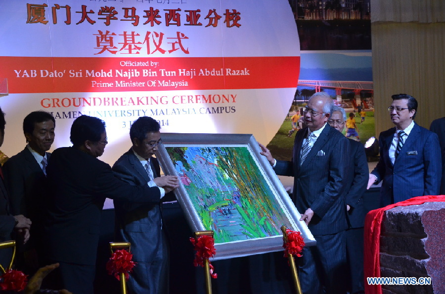 Zhu Chongshi (1th R), the President of Xiamen University, and Chen Shun (2th R), the Assistant Minister of Chinese Ministry of Education present an oil painting as a souvenir to Malaysian Prime Minister Najib Tun Razak (3th R). [Photo/Xinhua]