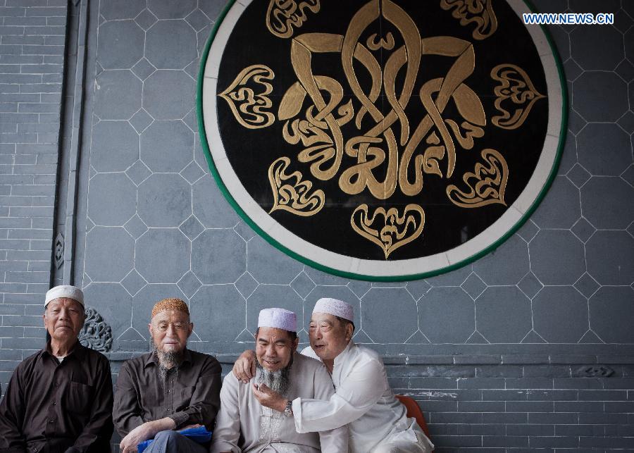 Muslims wait for praying at the Qingzhenzhongsi Mosque in Yinchuan, capital of Ningxia Hui Autonomous Region, July 3, 2014. Built in 1931, the mosque was located in downtown Yinchuan and known for its ancient-style architectures. [Photo/Xinhua]