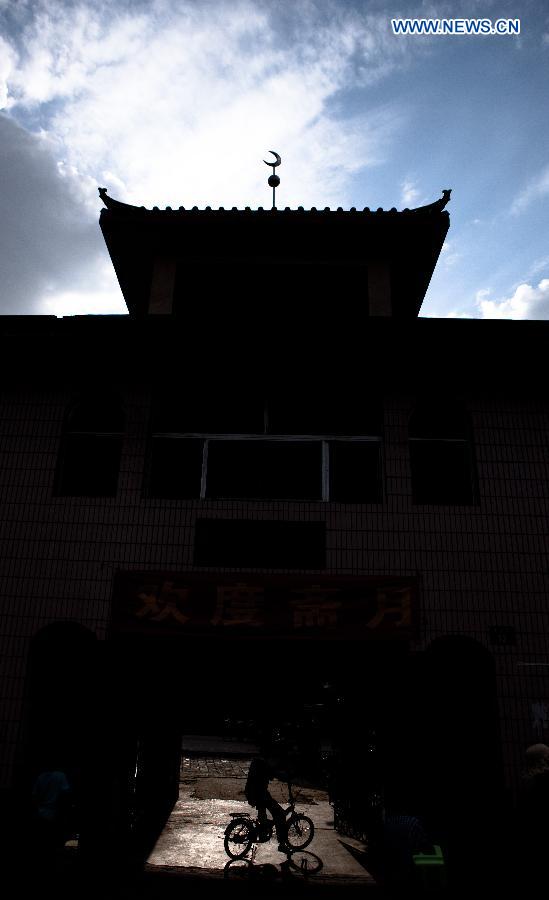 A Muslim rides to the Qingzhenzhongsi Mosque in Yinchuan, capital of Ningxia Hui Autonomous Region, July 3, 2014. Built in 1931, the mosque was located in downtown Yinchuan and known for its ancient-style architectures. [Photo/Xinhua]