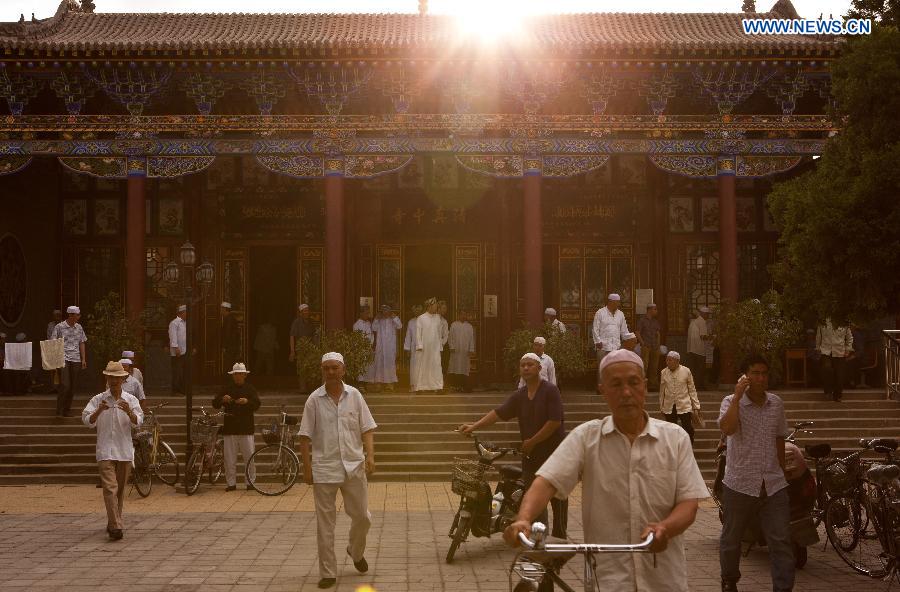 Muslims leave the Qingzhenzhongsi Mosque after praying in Yinchuan, capital of Ningxia Hui Autonomous Region, July 3, 2014. Built in 1931, the mosque was located in downtown Yinchuan and known for its ancient-style architectures. [Photo/Xinhua]