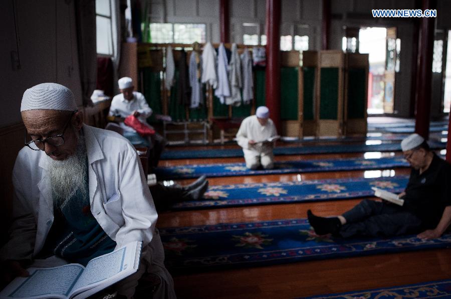 Muslims read scriptures at the Qingzhenzhongsi Mosque in Yinchuan, capital of Ningxia Hui Autonomous Region, July 3, 2014. Built in 1931, the mosque was located in downtown Yinchuan and known for its ancient-style architectures. [Photo/Xinhua]