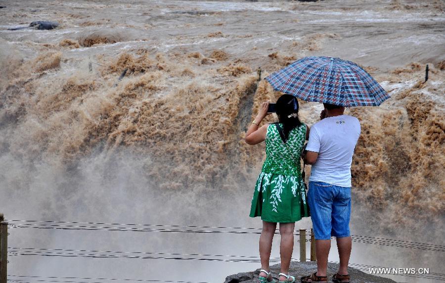 Tourists take photos of the Hukou Waterfall of the Yellow River, north China's Shanxi Province, July 9, 2014. [Photo/Xinhua]