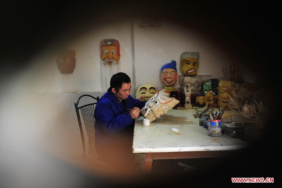 Folk artisan works on Nuo Opera masks