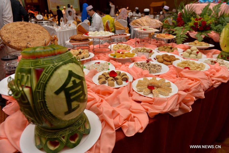 Local residents try out the Halal food presented by China Cuisine Association during a tasting event in Kuala Lumpur, Malaysia, July 5, 2014. [Photo/Xinhua]