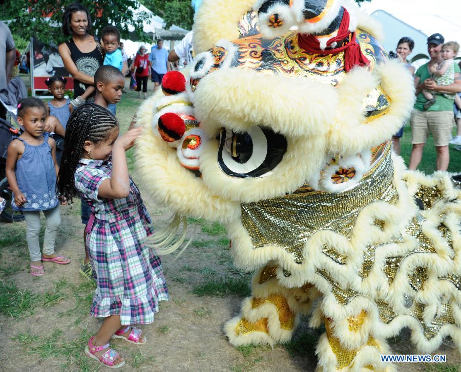 Kids watch lion dance during the 48th Smithsonian Folklife Festival in Washington D.C., capital of the United States, July 6, 2014. The 48th annual Smithsonian Folklife Festival closed in Washington on Sunday. [Photo/Xinhua]