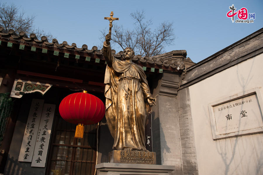 The bronze statue of St. Francis Xavier, who contributed to the growth of the Cathedral of the Immaculate Conception (colloquially known as the Xuanwumen Church, the South Church, or Nantang) in Beijing stands outside of the church gate on Christmas Day, Dec. 25, 2013. [Photo by Chen Boyuan / China.org.cn]