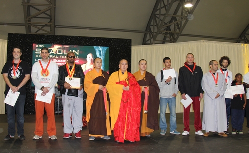 The Shaolin Temple Abbot Shi Yongxin takes a photo with winners of the Kungfu competition at the closing ceremony of Shaolin Cultural Festival in London, UK on Oct 12, 2014. [Photo/Xinhua]