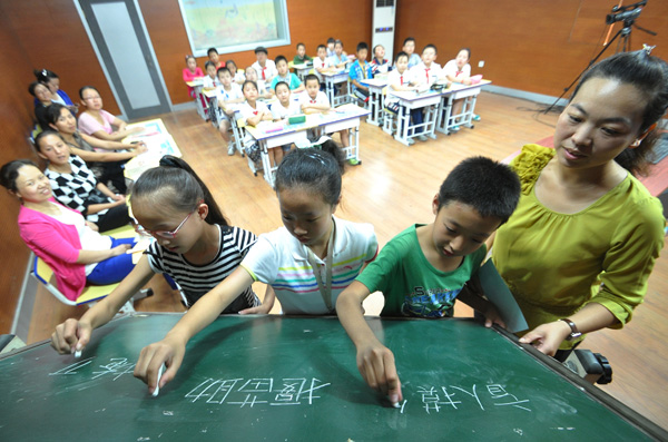 Pupils take part in a Chinese character dictation contest in Handan, Hebei Province on September 13, 2014. [Hao Qunying/Asianewsphoto]