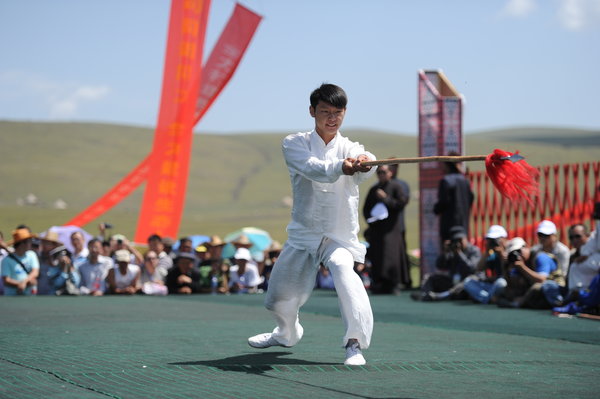 A martial arts master performs with a spear during the Tianshan Mountain Cultural Week in Tekes county, August 3, 2013. 